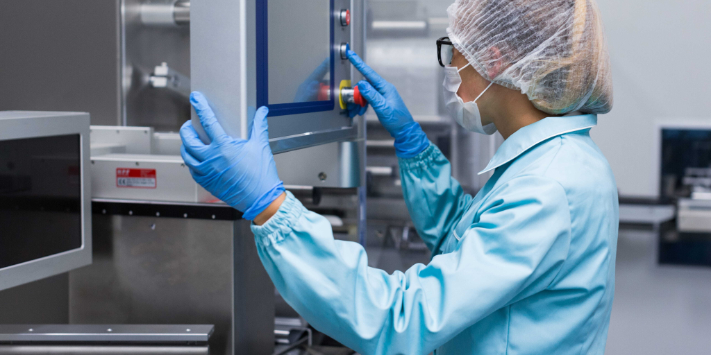 Technicienne de labo en blouse bleue qui réalise un étalonnage