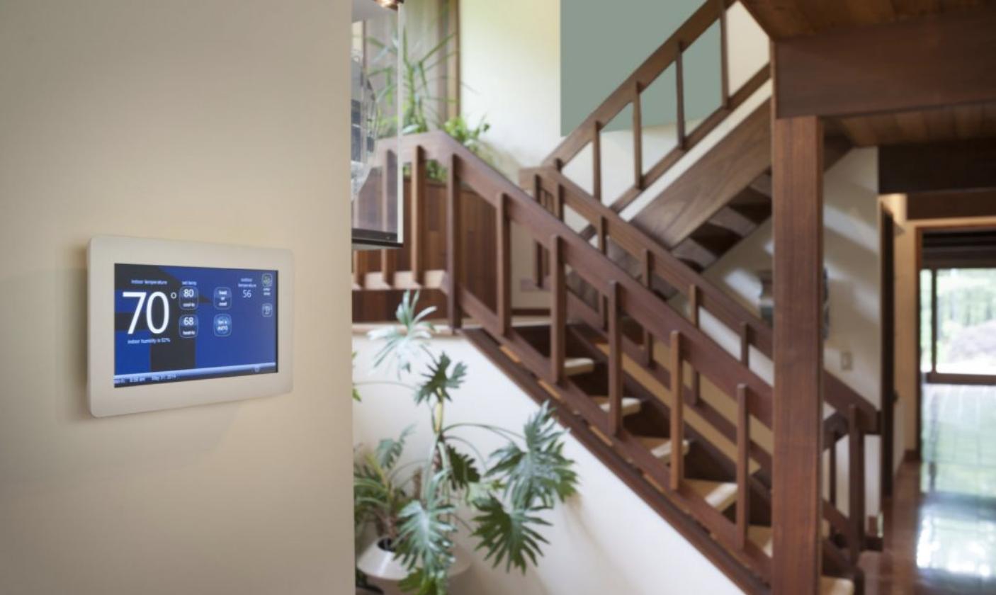 Thermostat connecté fixé au mur dans une maison lumineuse