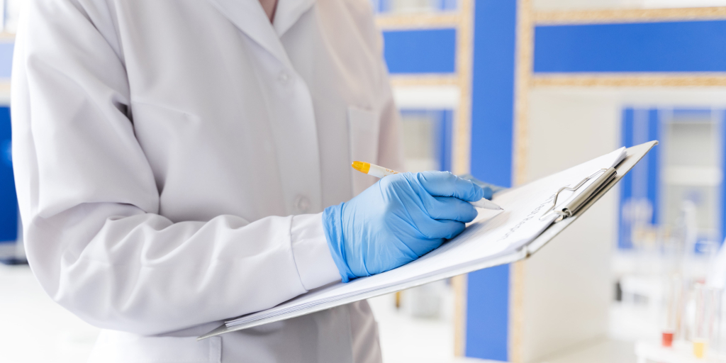 Technicien en blouse blanche saisit des résultats de laboratoire