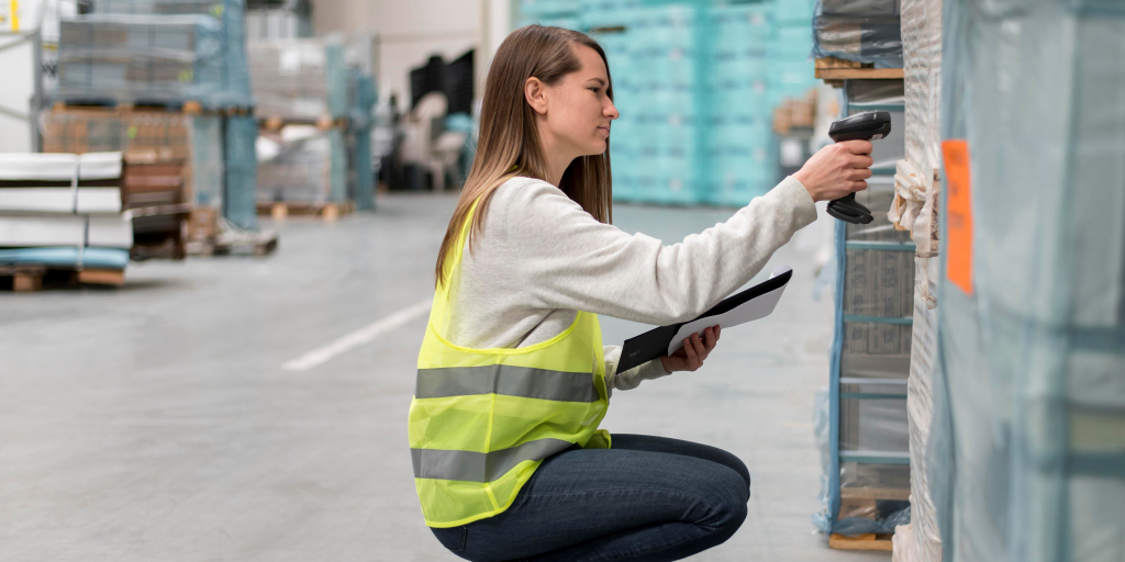 Technicienne scannant une palette pour le suivi des stocks et la traçabilité logistique