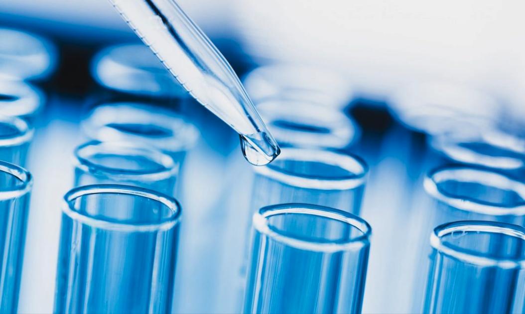 Pipette déposant un échantillon dans une série de tubes à essai